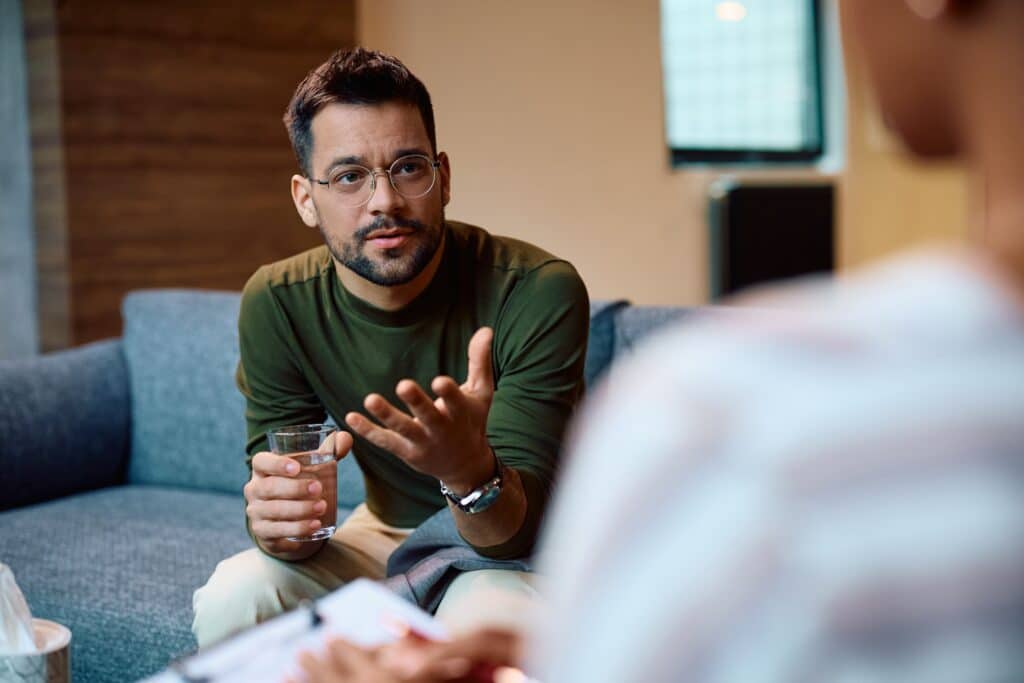man in therapy for anxiety avoidance talking with hands
