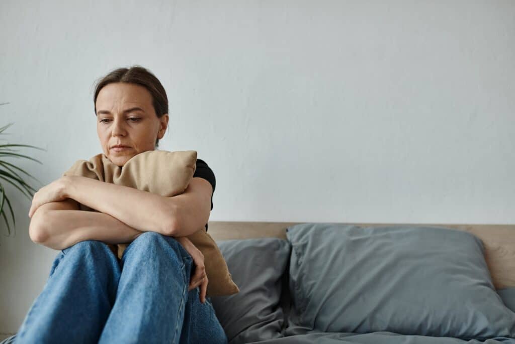 woman hugging pillow with anxiety