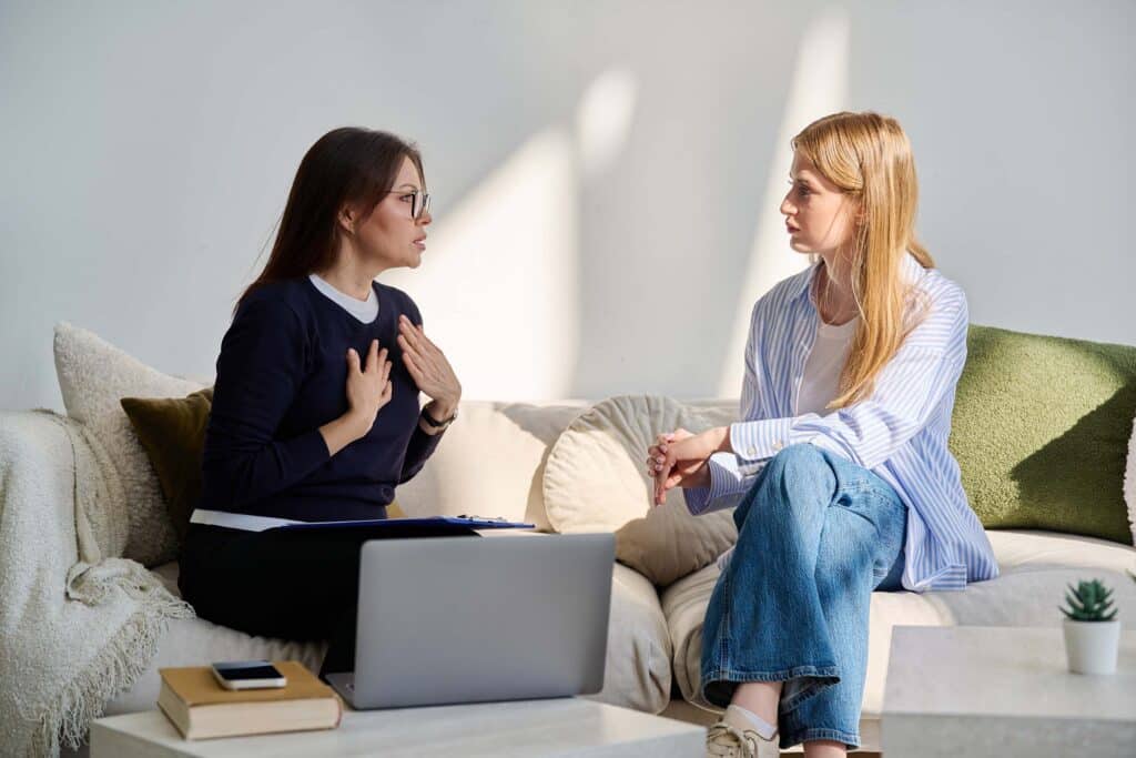 Young woman patient in mental session talking with professional psychologist