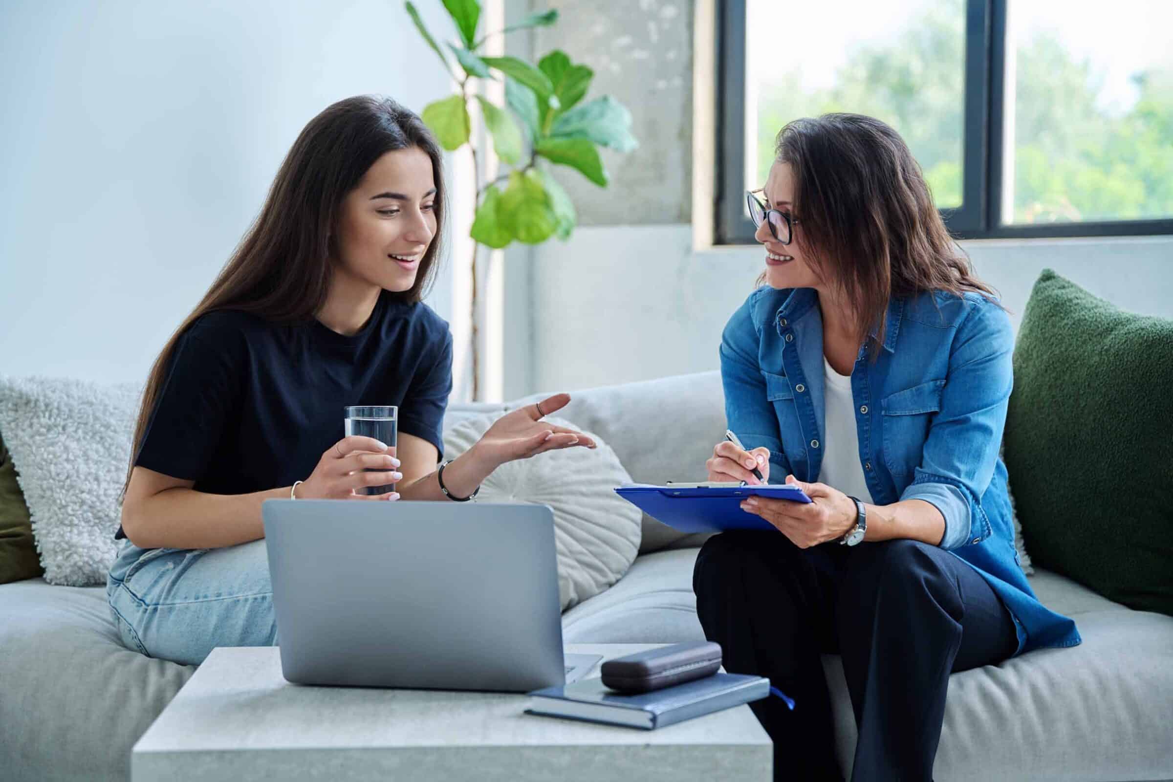 Young smiling girl patient in therapy session with therapist.