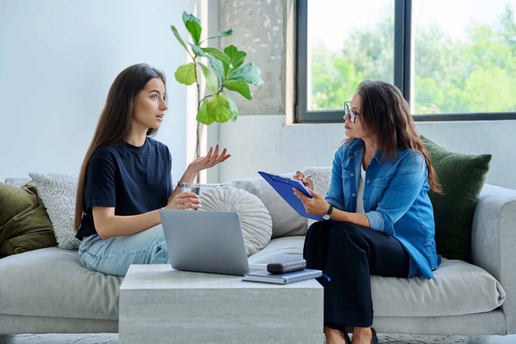 Teenage girl patient in therapy session with social mental therapist