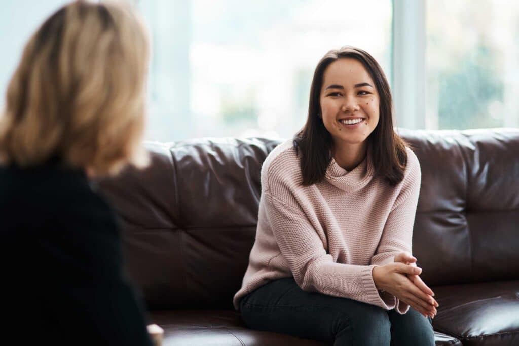 Therapy, happy women have a conversation on sofa and speaking or talking with a psychologist.